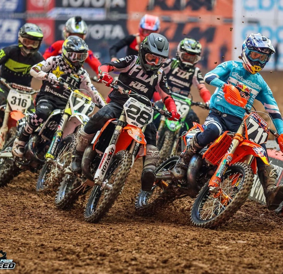 A pack of motocross riders off the start gate