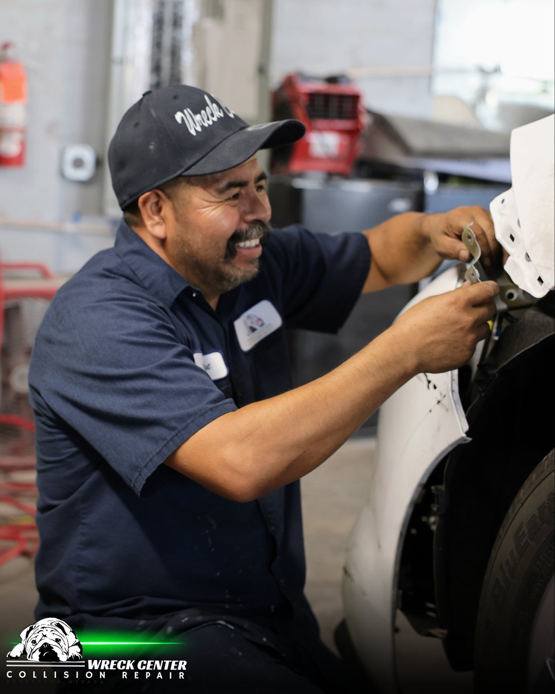 A technician fitting a panel at a collision repair shop